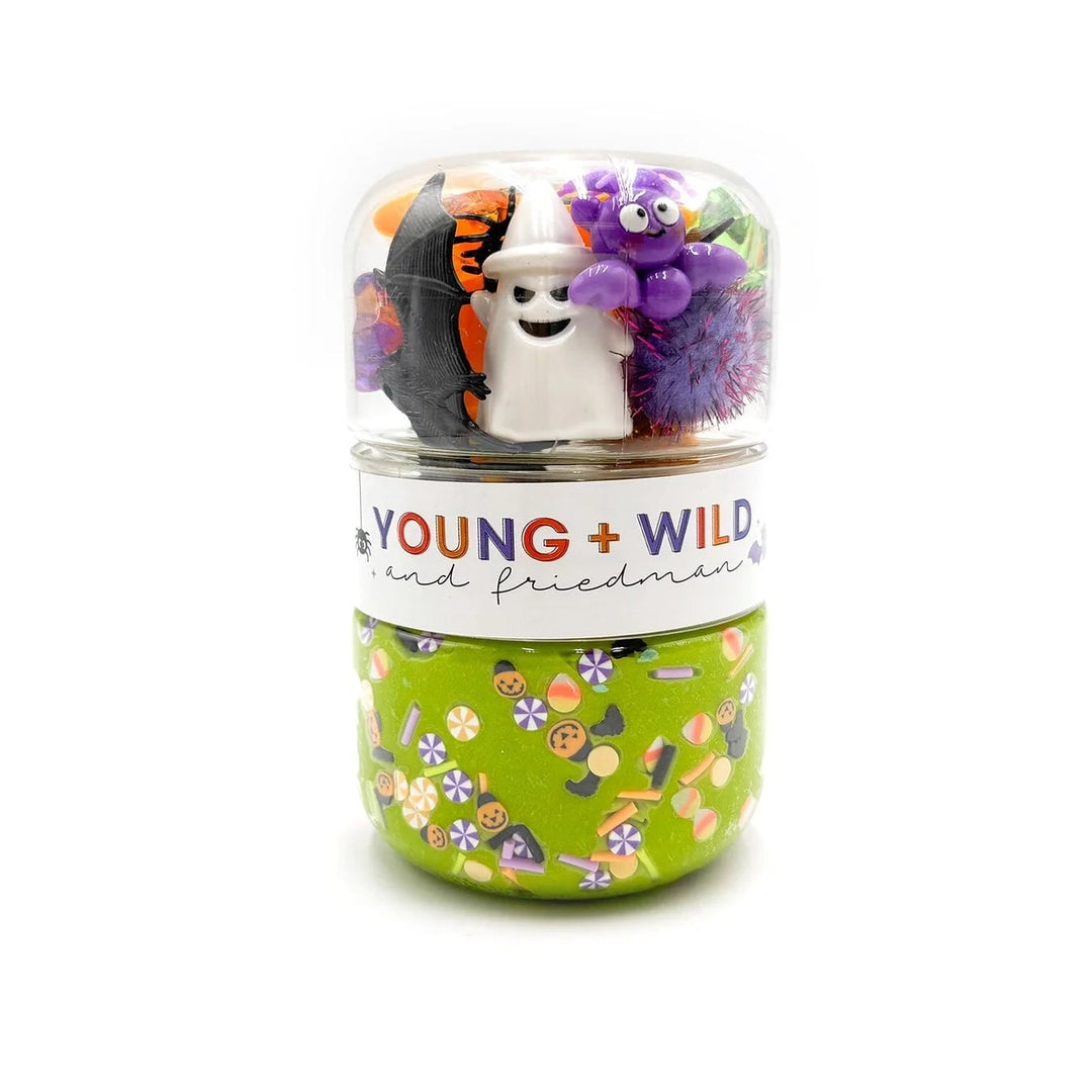 Decorative container with small figurines and 'Young + Wild and Free' text on a white background