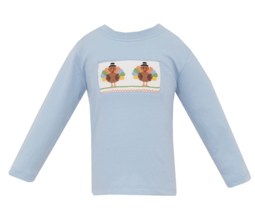 A light blue long-sleeve baby shirt with a rectangular graphic on the chest showing two cartoon turkeys wearing black hats. A smaller inset view on the right shows the graphic laid flat.