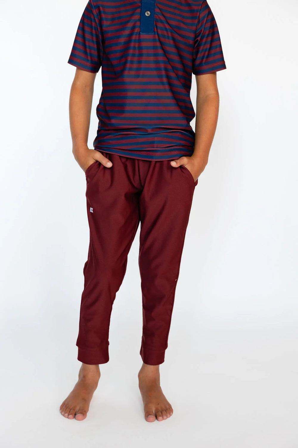 Person wearing a striped shirt and burgundy pants on a white background