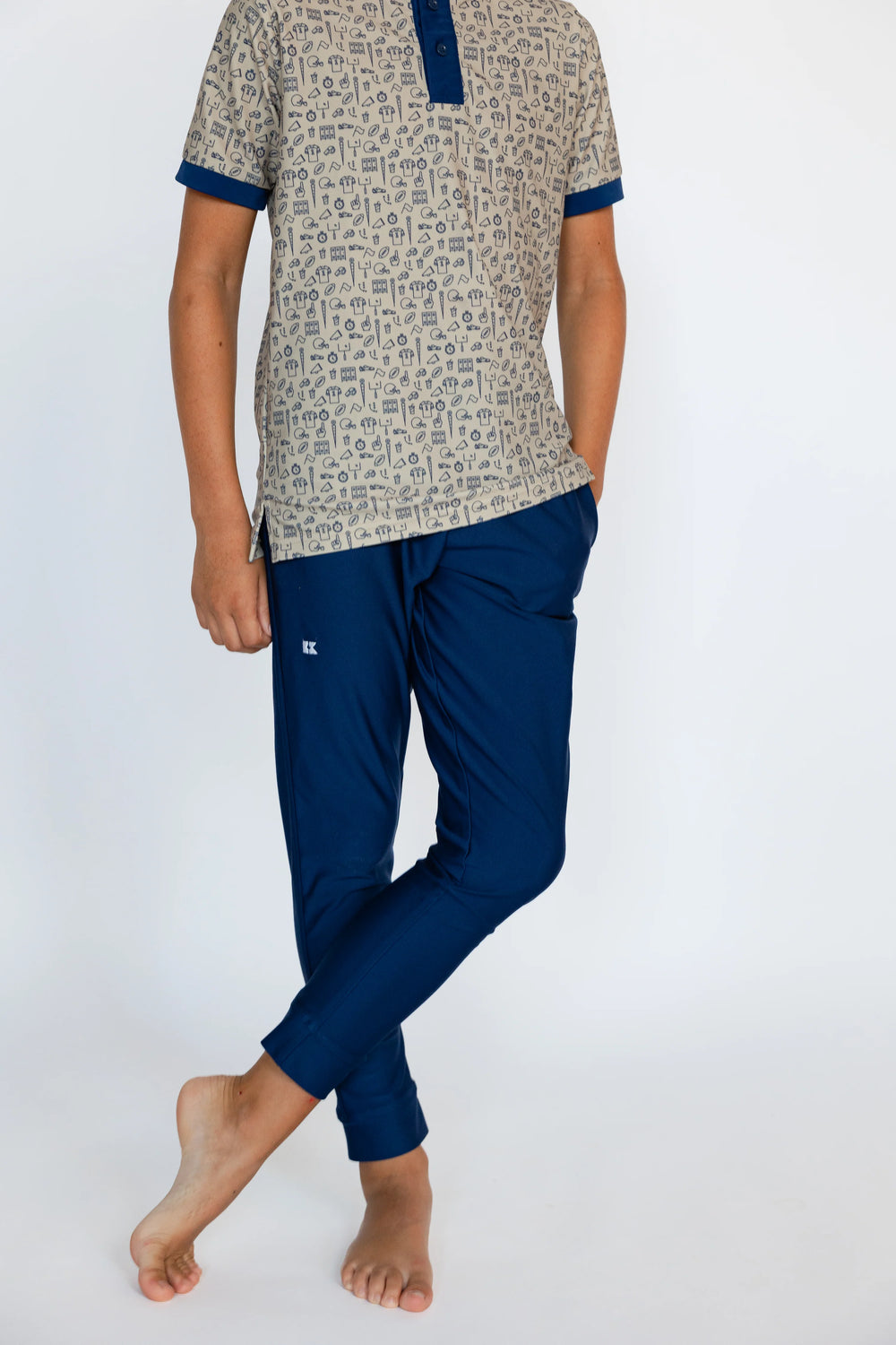 Person wearing a patterned shirt and blue pants on a white background