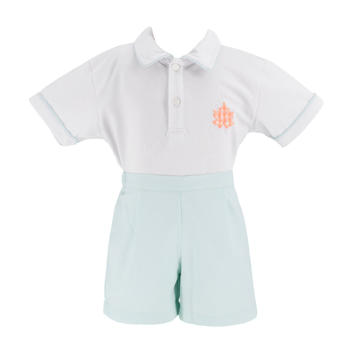 A two-piece polo set featuring a white short-sleeve polo shirt with a light blue collar and sleeve trim, and light mint green shorts. The polo shirt has a small orange embroidered monogram logo on the left chest.