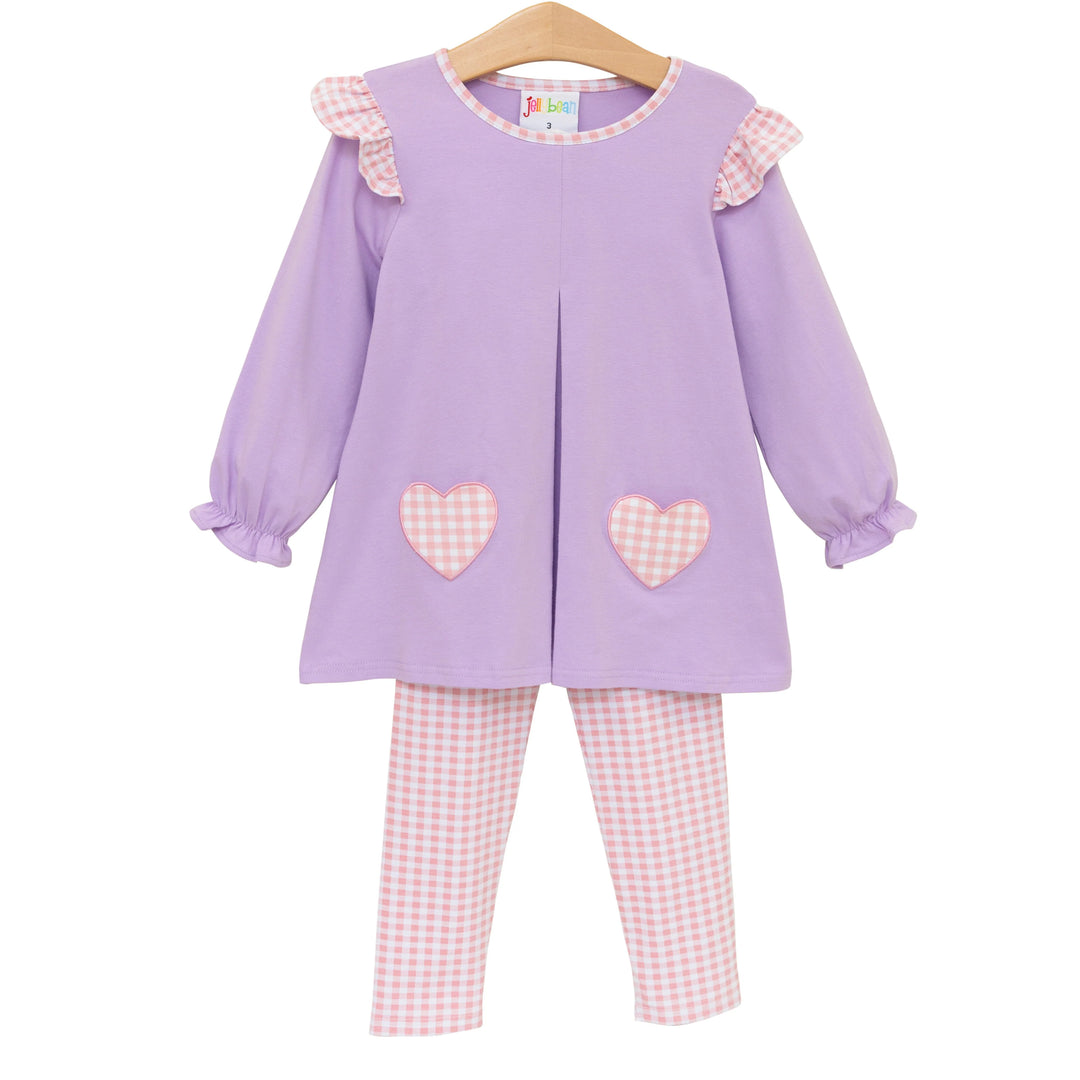 Children's outfit with purple top and pink checkered pants on a white background