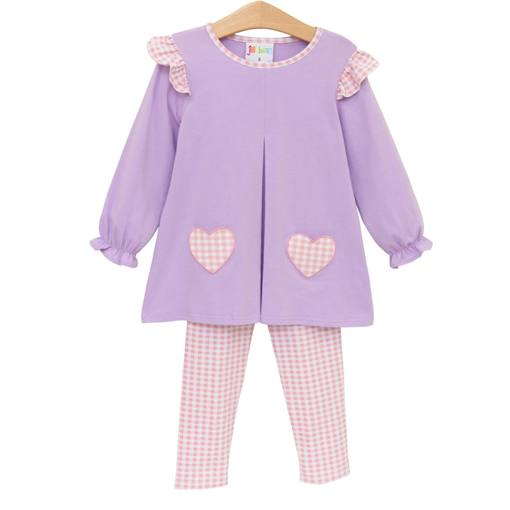 Children's outfit with purple top and pink checkered pants on a white background