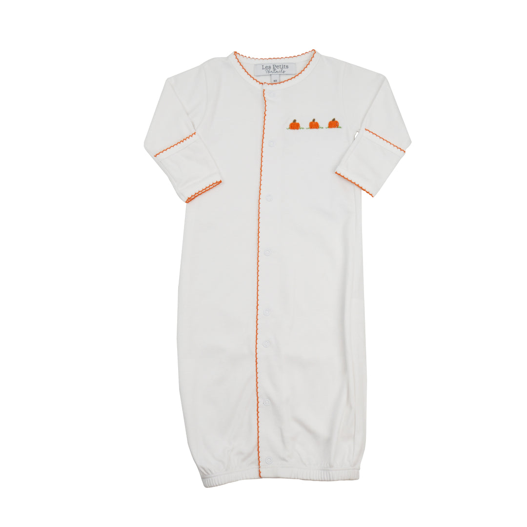 An off-white long-sleeve baby sleep sack with orange contrast stitching and a small pumpkin graphic on the chest, shown against a plain white background.