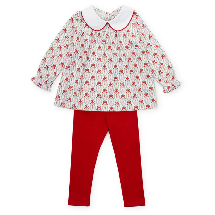Children's outfit with patterned top and red pants on a white background