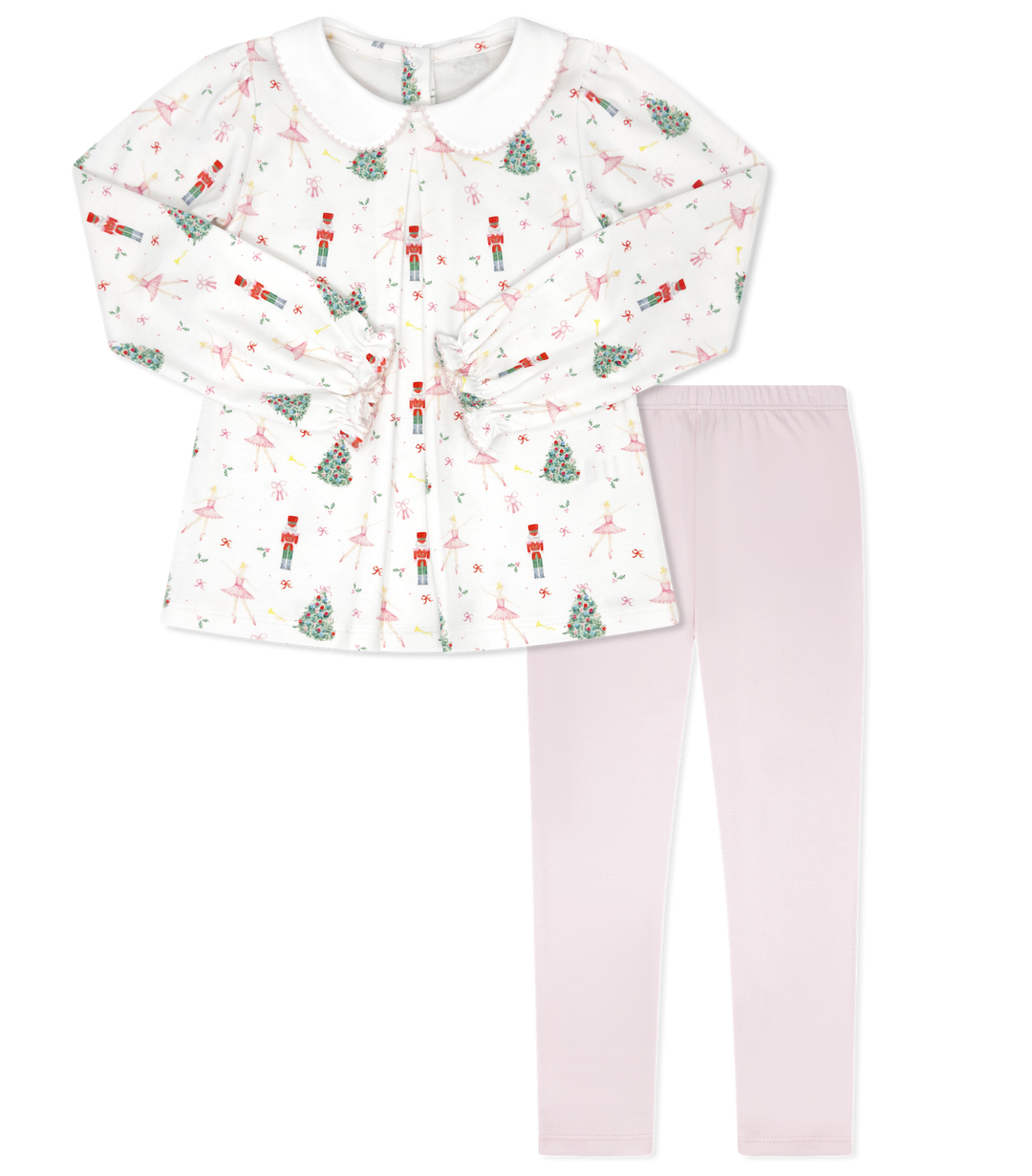 Children's outfit with patterned top and pink leggings on a white background
