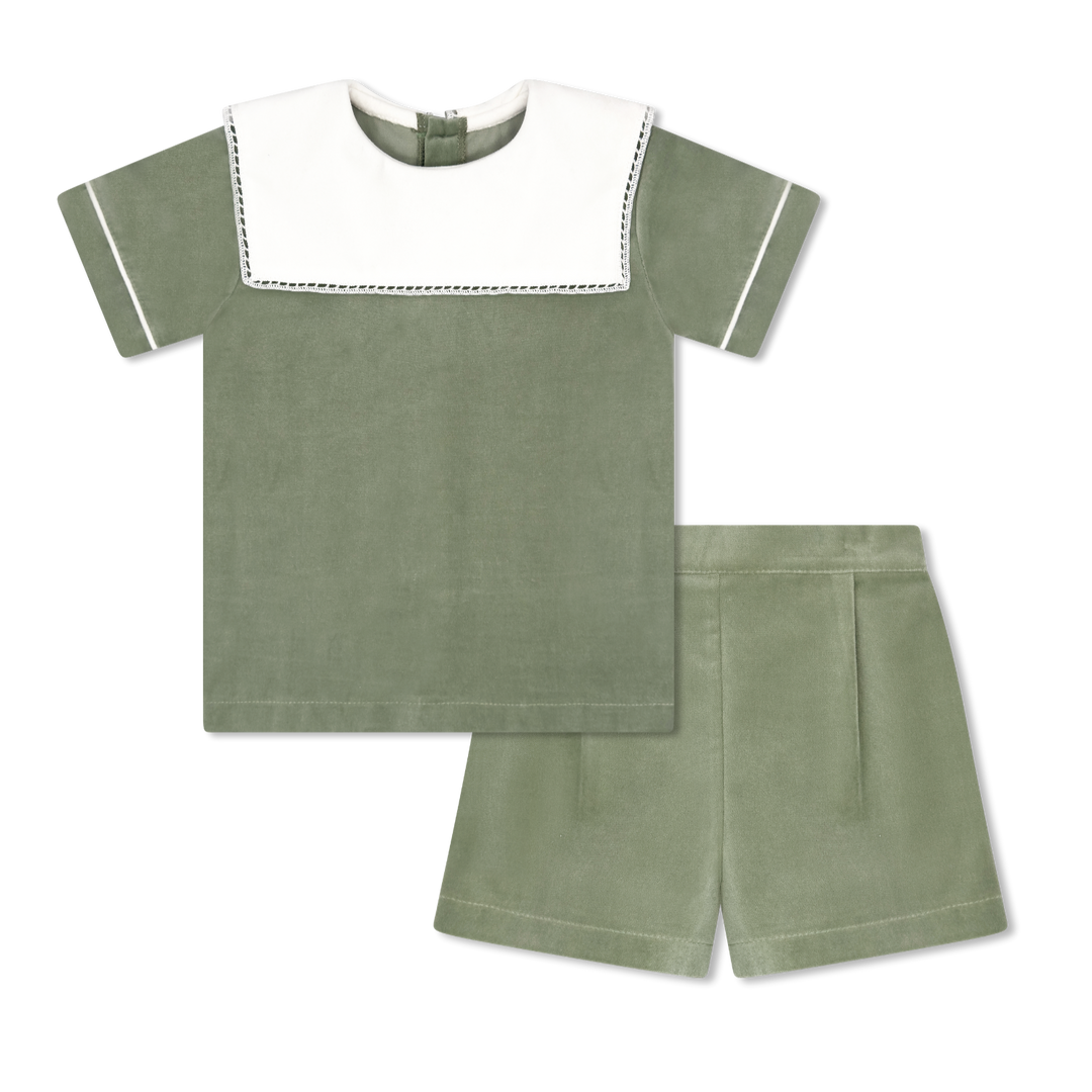 Green children's outfit with white trim on a white background