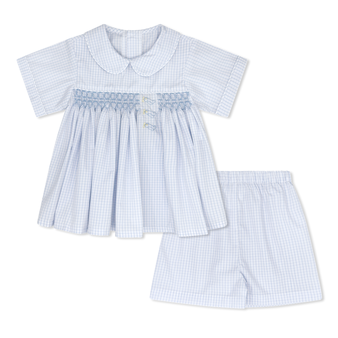 Children's outfit with a blue checkered dress and shorts on a white background