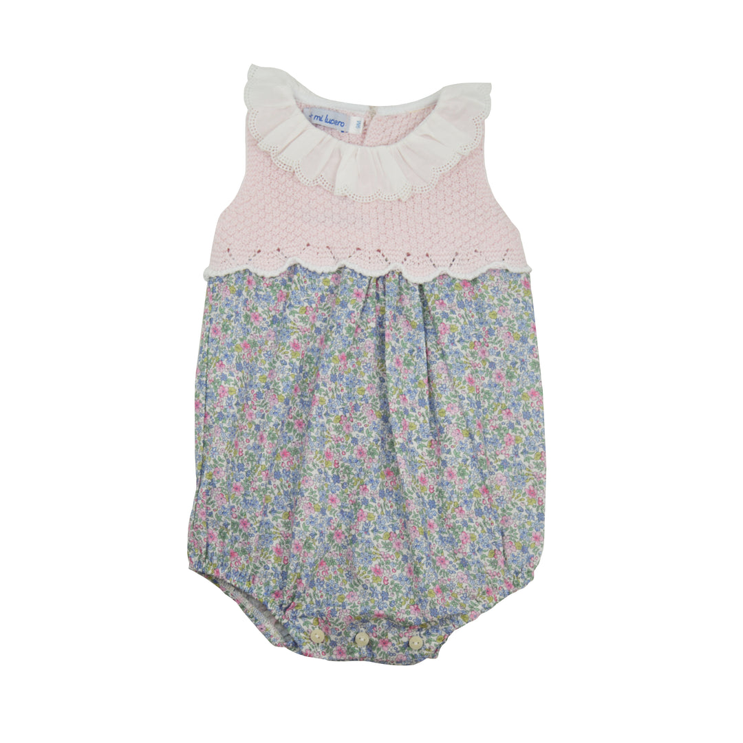 Baby romper with floral pattern and pink lace top on a white background
