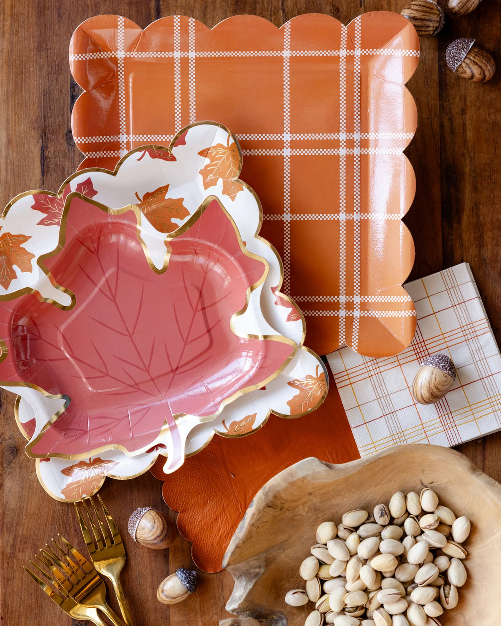 Decorative leaf-shaped plates with a plaid background on a wooden surface.