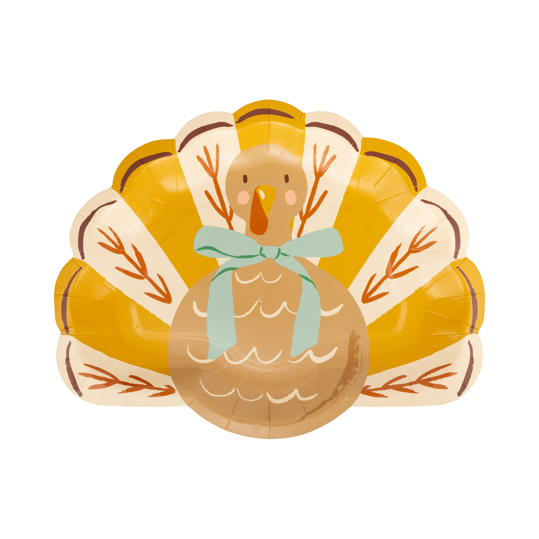 A decorative paper plate shaped like a turkey, with a mustard yellow fan background, a tan turkey body, brown branch details, and a mint green bow, shown on a plain white background.
