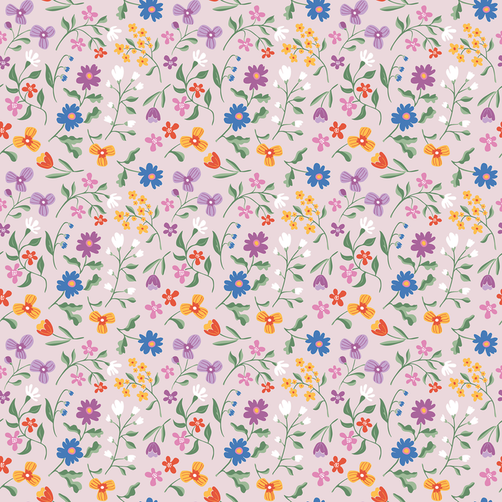 A seamless repeating floral pattern featuring a variety of small wildflowers in blue, purple, orange, pink, and white on a soft, pale pinkish-beige background.