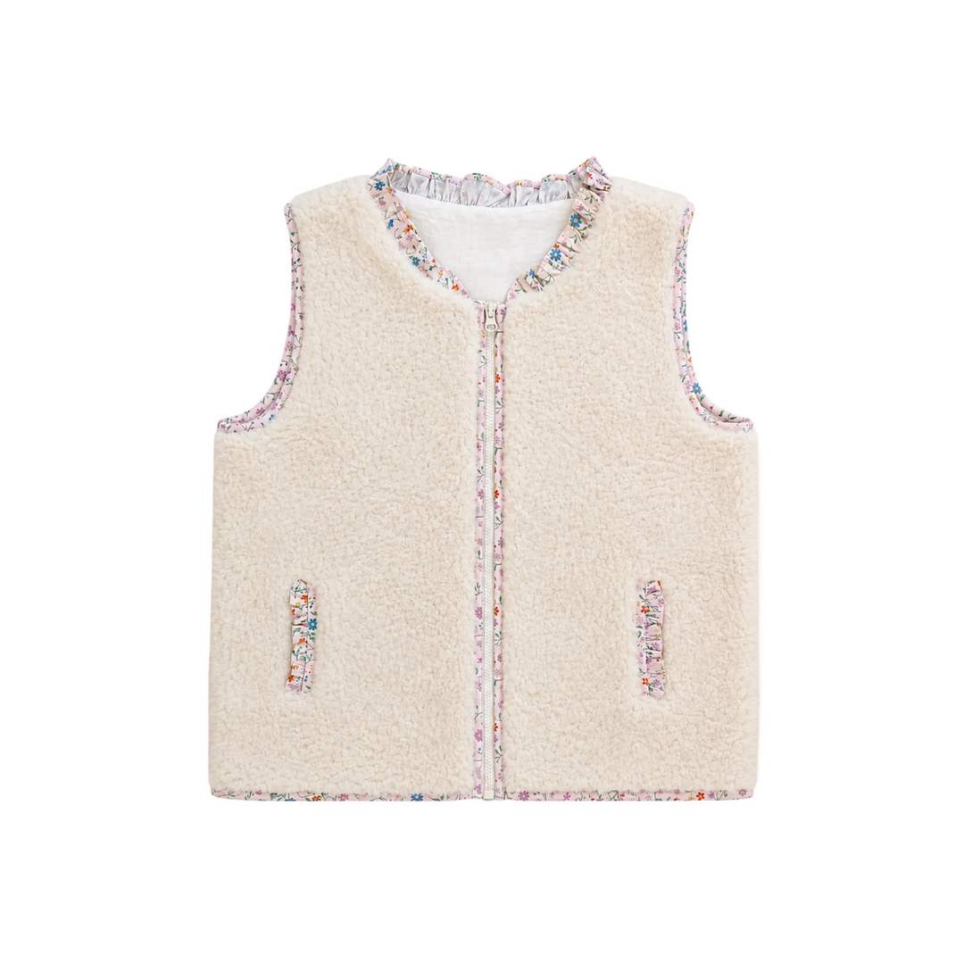 A sleeveless cream-colored fleece vest with multicolor speckled trim along the collar, front zipper, and pocket edges, shown flat on a light cream background.