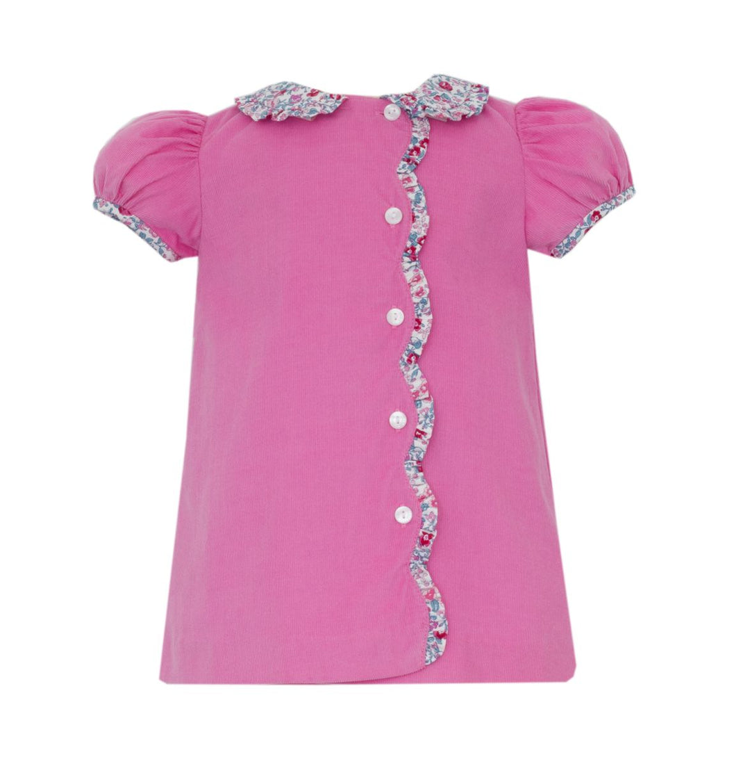 Pink dress with decorative buttons and trim on a white background