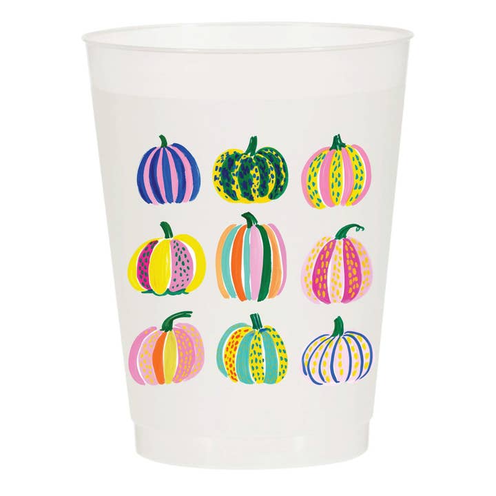 A clear plastic party cup decorated with a grid of nine colorful striped and patterned pumpkins, shown against a plain white background.