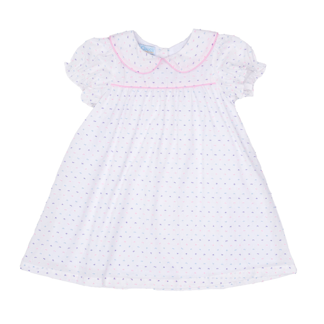 White dress with blue polka dots and pink trim on a white background