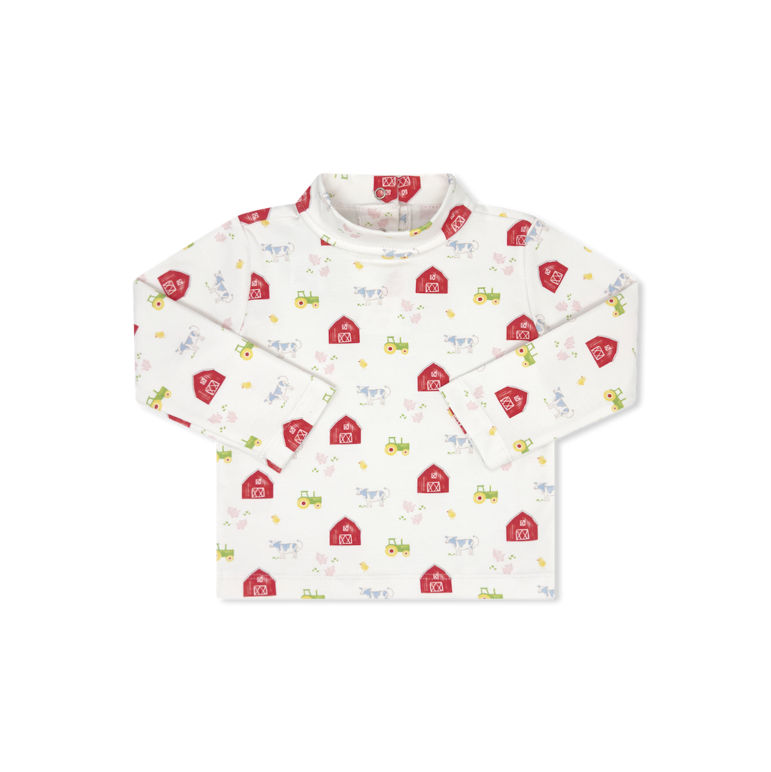 A long-sleeve baby shirt with a white base and a colorful print of red barns, yellow tractors, and small farm animals, shown flat on a white background.