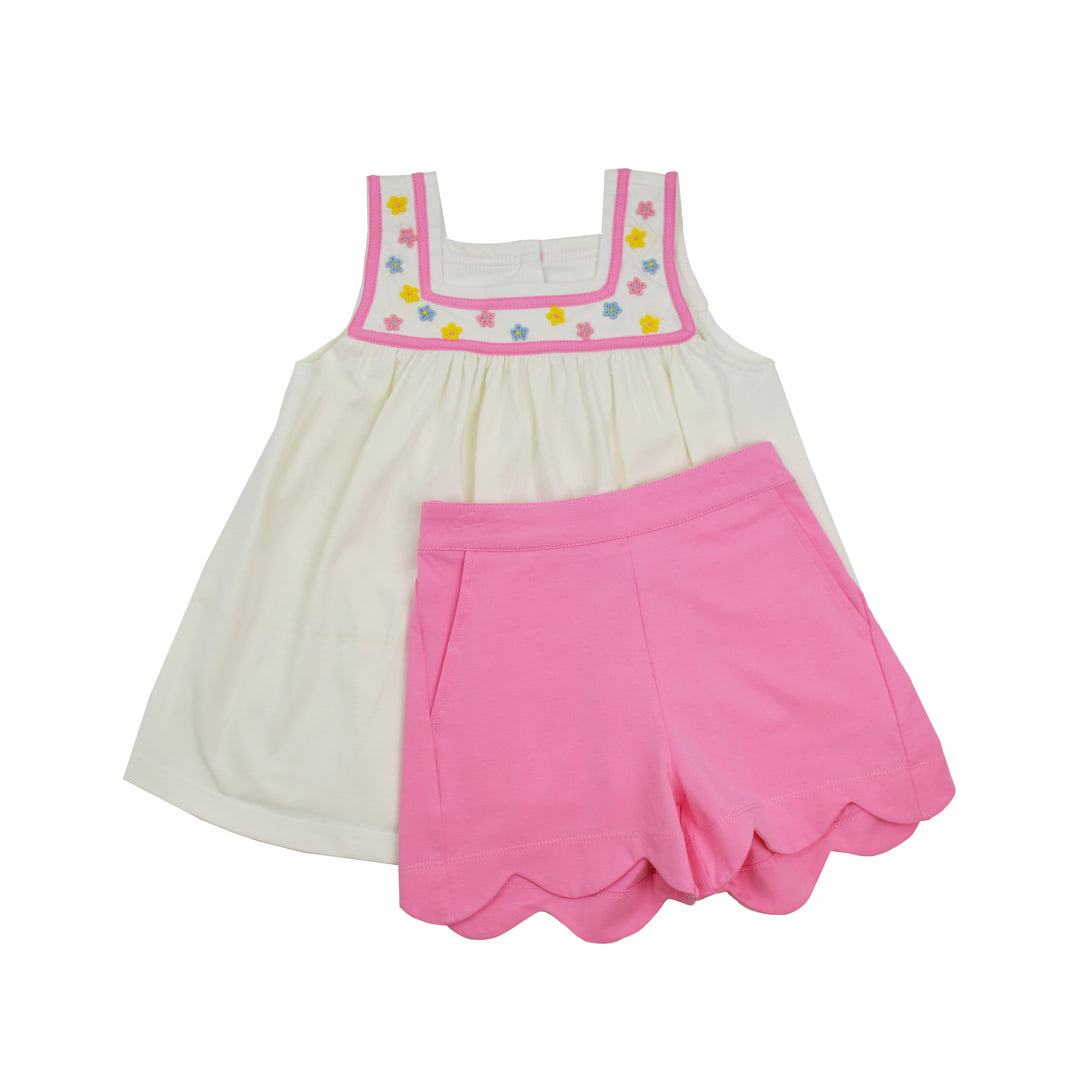 Children's outfit with a white top and pink shorts on a white background